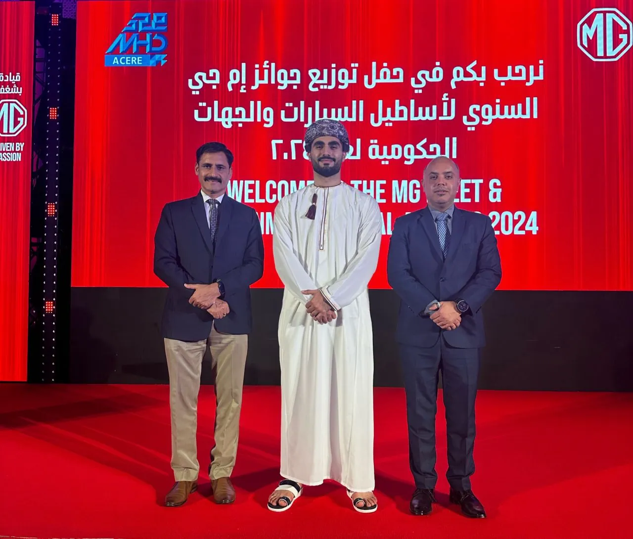Shihab Mebarez with two guests on stage at the MG Fleet and Government Annual Awards 2024, which he hosted