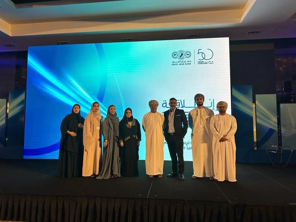Shihab Mebarez on stage with Oman Arab Bank's CEO and team at the bank's 50 years together event